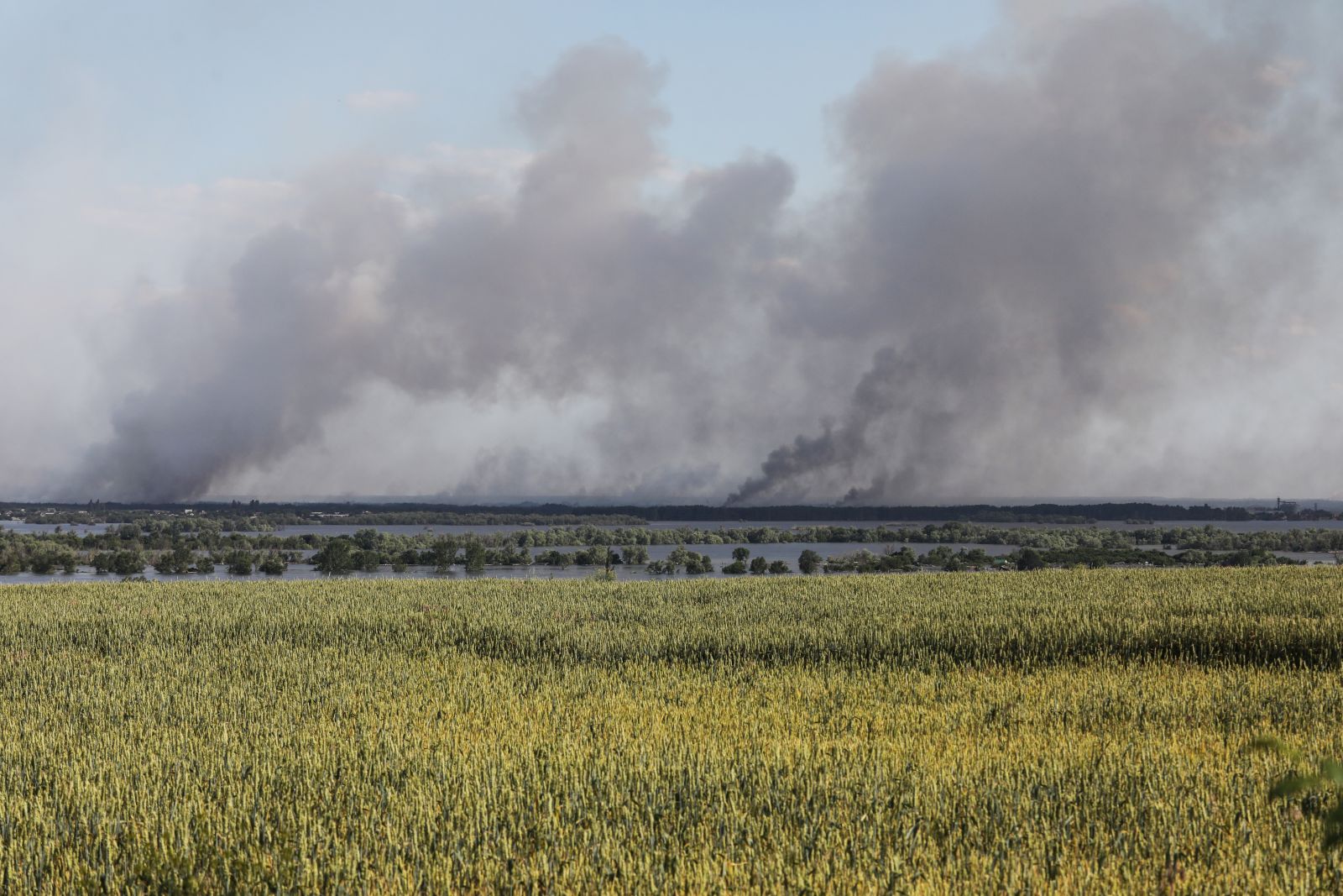 epa10680415 Smoke rises in the distance following shelling beyond the destroyed Antonivsky Bridge in the Kherson region, Ukraine, 08 June 2023. Ukraine has accused Russian forces of destroying a critical dam and hydroelectric power plant on the Dnipro River in the Kherson region along the front line in southern Ukraine on 06 June, leading to the flooding of a number of settlements.  EPA/MYKOLA TYMCHENKO