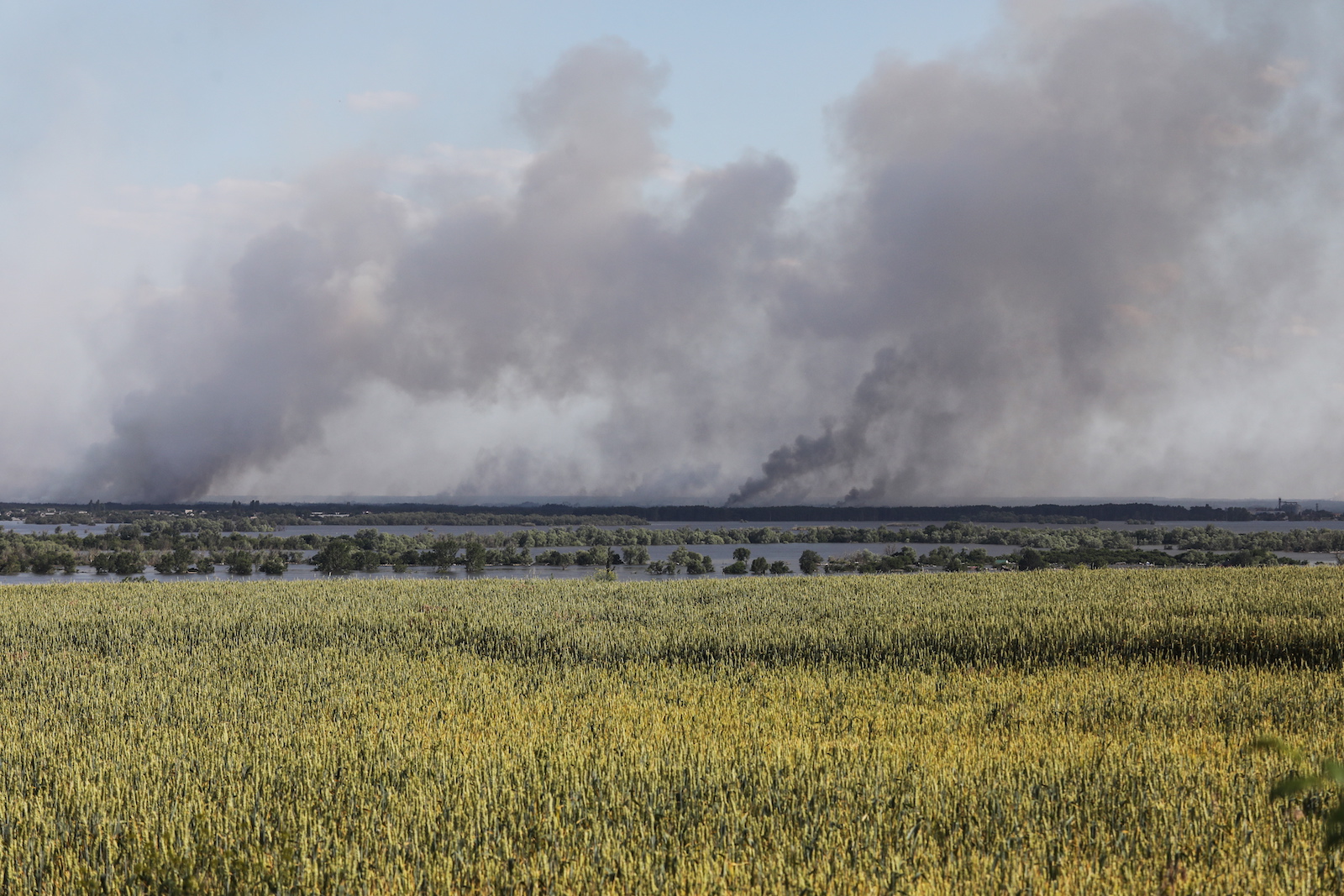 epa10680415 Smoke rises in the distance following shelling beyond the destroyed Antonivsky Bridge in the Kherson region, Ukraine, 08 June 2023. Ukraine has accused Russian forces of destroying a critical dam and hydroelectric power plant on the Dnipro River in the Kherson region along the front line in southern Ukraine on 06 June, leading to the flooding of a number of settlements.  EPA/MYKOLA TYMCHENKO