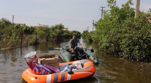 epa10681883 Volunteers deliver food to local residents in a flooded area of Kherson, Ukraine, 09 June 2023. Ukraine has accused Russian forces of destroying a critical dam and hydroelectric power plant on the Dnipro River in the Kherson region along the front line in southern Ukraine on 06 June, leading to the flooding of a number of settlements.  EPA/MYKOLA TYMCHENKO