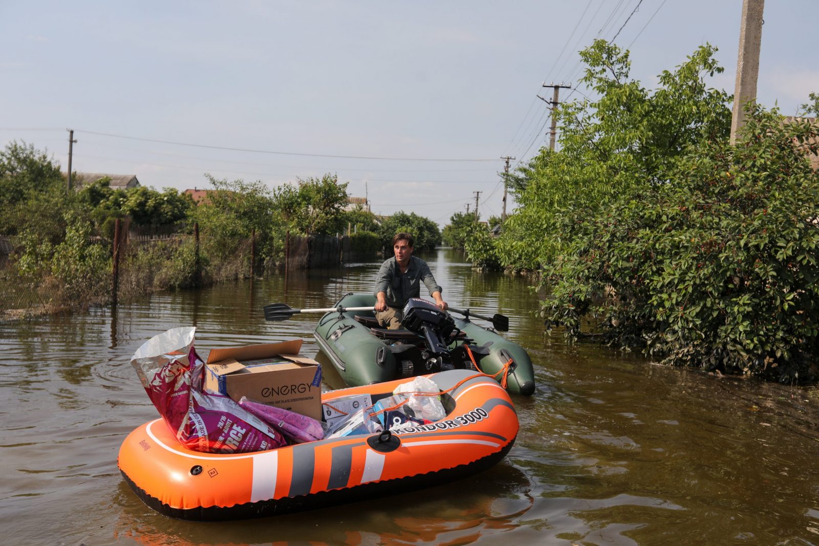 epa10681883 Volunteers deliver food to local residents in a flooded area of Kherson, Ukraine, 09 June 2023. Ukraine has accused Russian forces of destroying a critical dam and hydroelectric power plant on the Dnipro River in the Kherson region along the front line in southern Ukraine on 06 June, leading to the flooding of a number of settlements.  EPA/MYKOLA TYMCHENKO