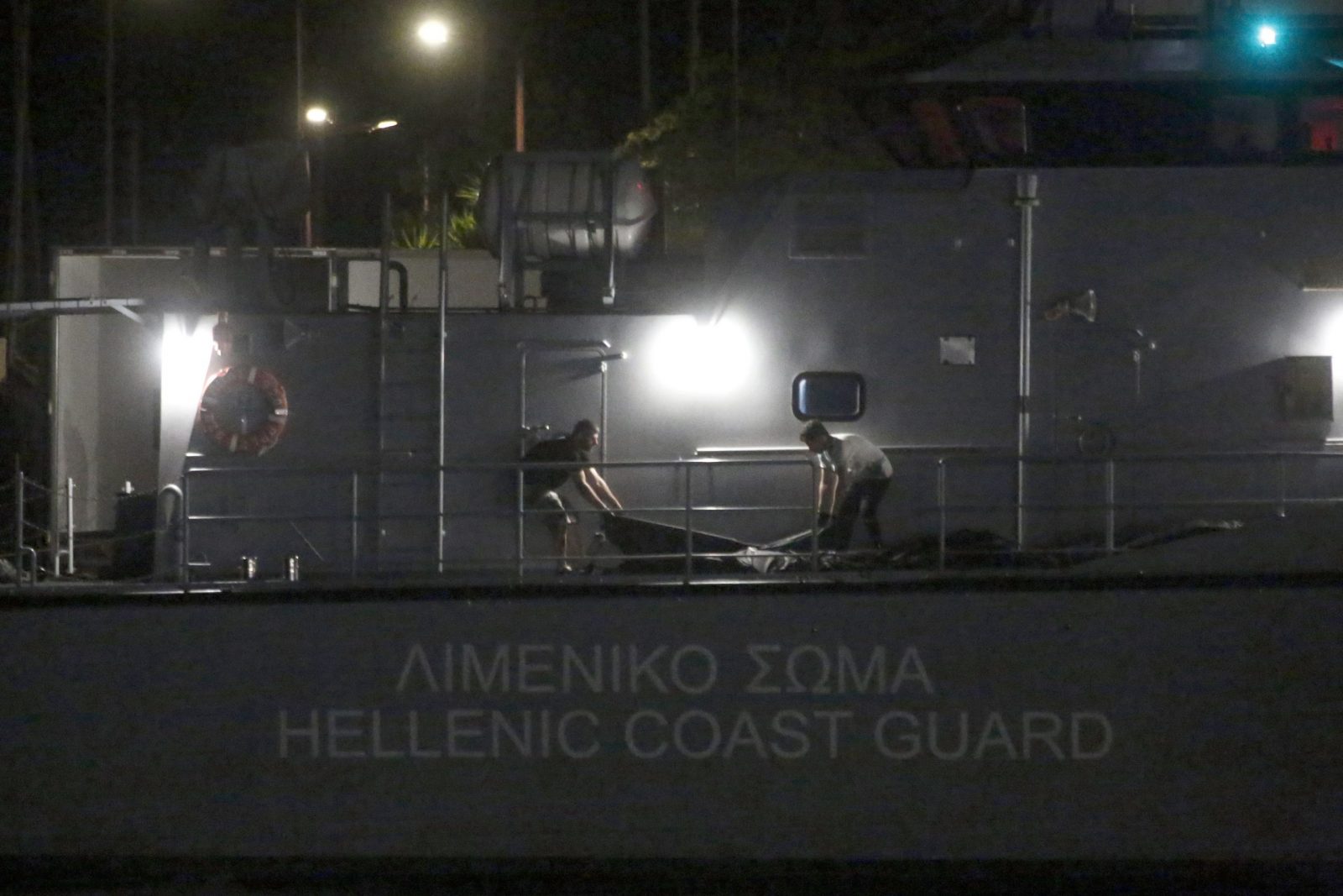 epaselect epa10691388 Greek coast guard personal carry the dead bodies of refugees and migrants from a coast guard ship following a deadly shipwreck off Pylos at the port of Kalamata, southwest of Athens, Greece, 15 June 2023. A total of 104 individuals were rescued, while 79 bodies were recovered, after a fishing boat capsized in international waters 47 nautical miles southwest of the Peloponnese coast and the town of Pylos.  EPA/YANNIS KOLESIDIS
