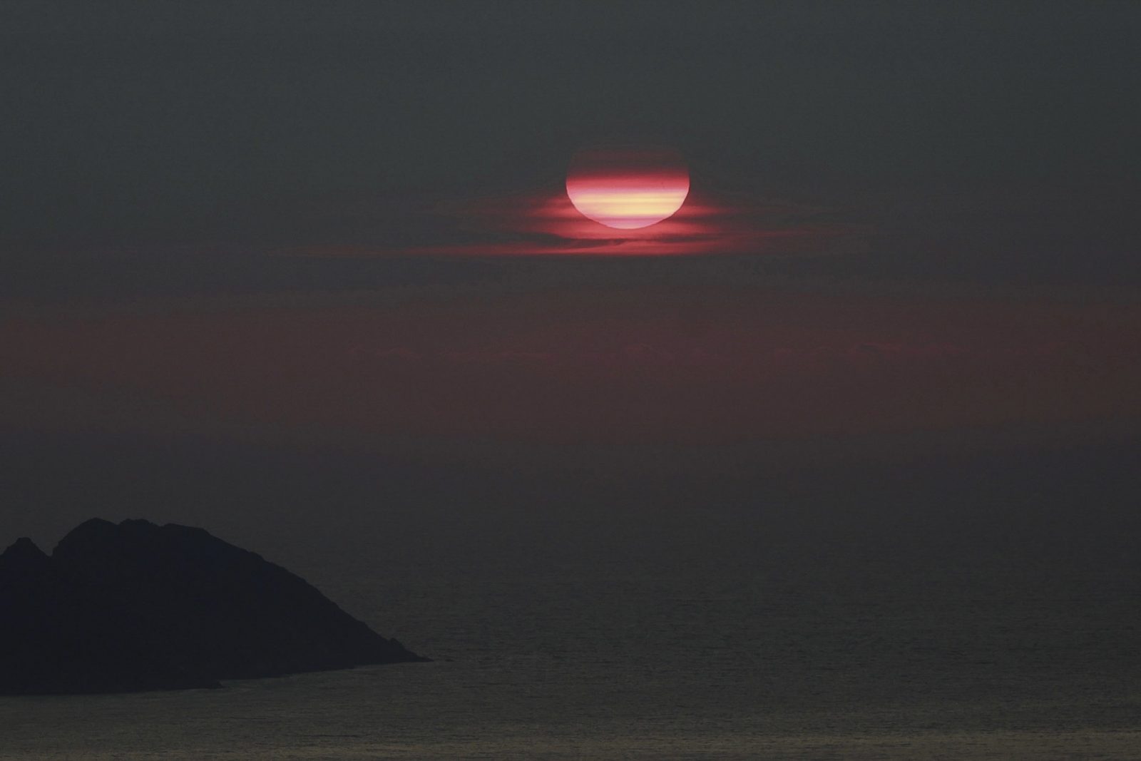 epa10712105 Smoke from the wildfires affecting Canada rises over Mount Cepudo, in the city of Vigo, northwestern Spain, 25 June 2023 (issued 26 June 2023). The smoke from the fires in Canada has reached Galicia after traveling thousands of kilometers in the upper layers of the atmosphere, although it only generates a slight reduction in visibility without affecting air quality, as Carlos Otero, a MeteoGalicia meteorologist, explained to EFE.  EPA/SXENICK