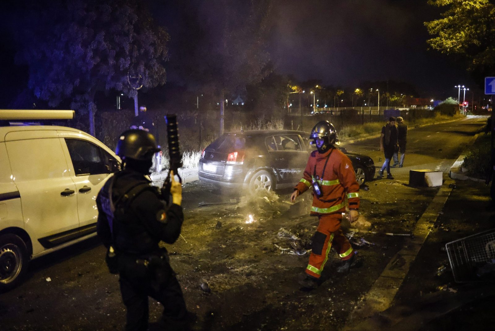 epaselect epa10716062 French firefighter and French riot Police officer walk near a garbage fire in Nanterre, near Paris, France, 28 June 2023. The violence broke out after police fatally shot a 17-year-old during a traffic stop in Nanterre. According to the French interior minister, 31 people were arrested with 2,000 officers being deployed to prevent further violence.  EPA/YOAN VALAT