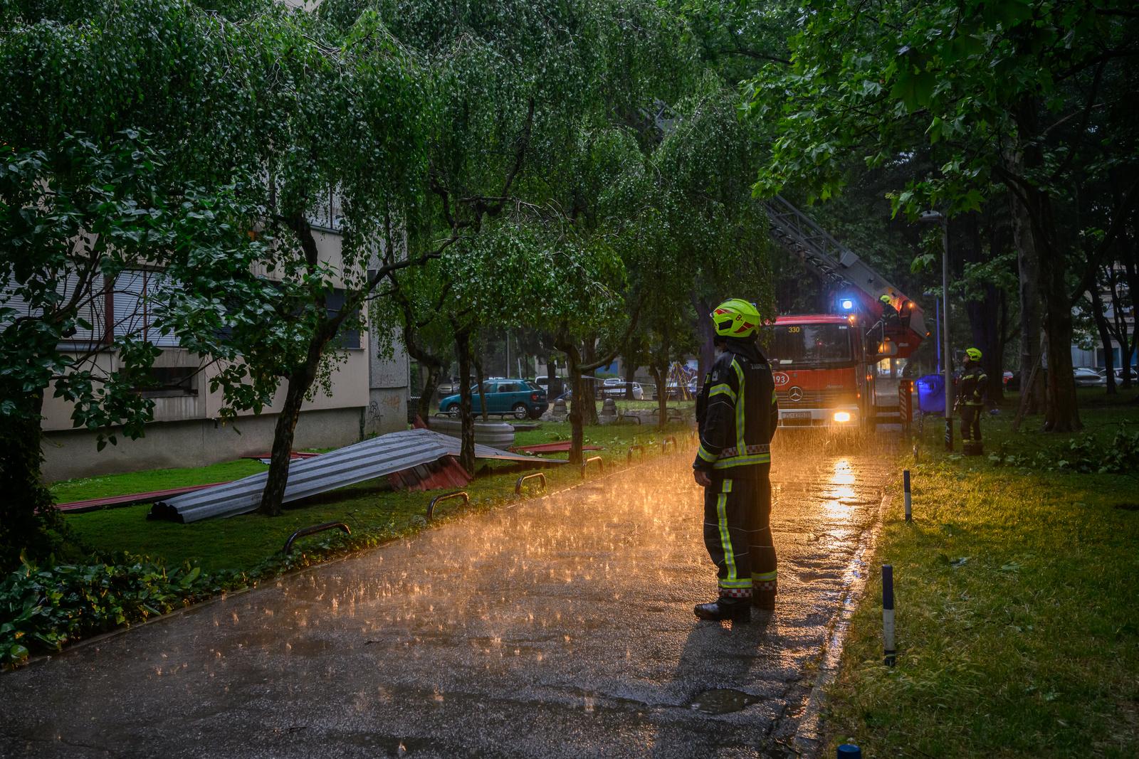 23.06.2023., Zagreb - Olujno nevrijeme odnijelo je dio limenog krova na stambenoj zgradi u ulici Gustava Krkleca 30. Vatrogasci uklanjaju ostale komade lima koji ugrozavaju gradjane.
 Photo: Davor Puklavec/PIXSELL