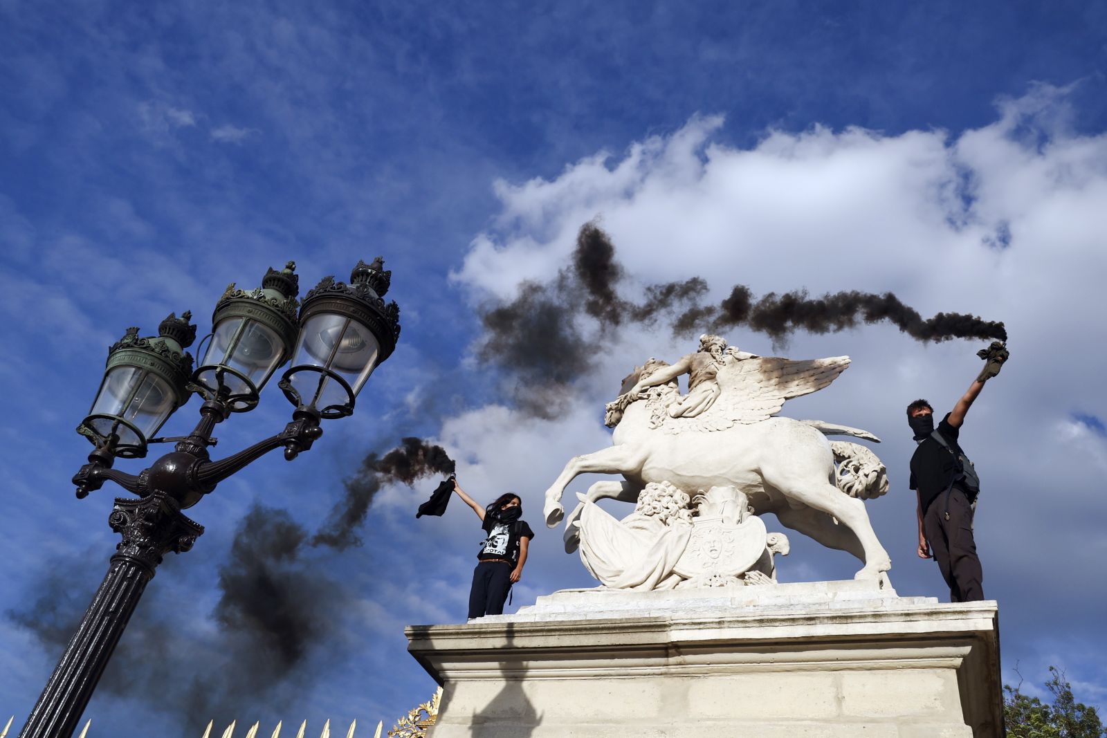epa10719742 Demonstrators hold up smoke flares during a protest in memory of 17-year-old Nahel, who was killed by French police, in Paris, France, 30 June 2023. Violence broke out all over France after police fatally shot a 17-year-old teenager during a traffic stop in Nanterre on 27 June.  EPA/MOHAMMED BADRA