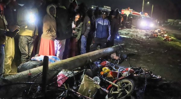 epa10720199 People mill around and search through the aftermath of a traffic accident in Londiani Junction area along the Kericho-Nakuru highway in Kericho County, Kenya's Rift Valley region, Kenya, 01 July 2023. According to a statement from Regional police commander Tom Odera, at least 48 people have been confirmed dead in the road accident, during which a truck carrying a shipping container rammed into several other vehicles and market traders along the Nakuru-Kericho highway.  EPA/STR