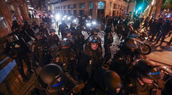 epaselect epa10721741 Riot police forces secure the area near the Arc de triomphe during another night of clashes with protestors in Paris, France, 01 July 2023. Violence broke out all over France after police fatally shot a 17-year-old teenager during a traffic stop in Nanterre on 27 June.  EPA/MOHAMMED BADRA