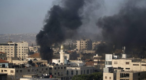 epa10726344 Smoke rises among buildings during clashes with the Israeli army on the second day of a military operation in Jenin camp, West Bank, 04 July 2023. The Israeli army stated on 03 July that they launched a large-scale operation in Jenin. According to the Palestinian Health Ministry, at least ten people were killed and dozens of others wounded in the raid, adding that the death toll was likely to rise.  EPA/ALAA BADARNEH