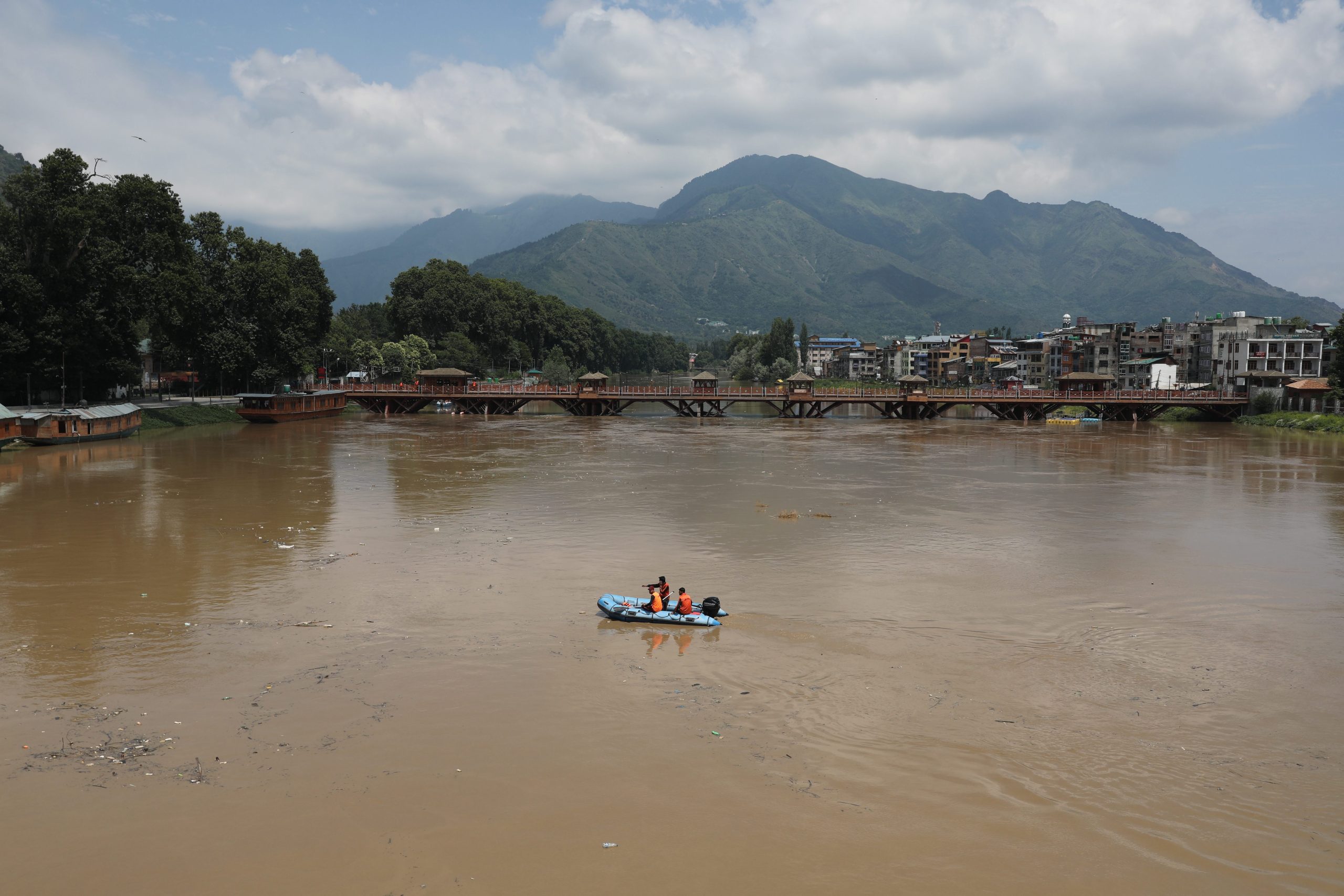 epa10736544 Indian police officers patrol on a boat on Jhelum river in Srinagar, the summer capital of Indian Kashmir, 09 July 2023. The threat of flooding in Kashmir was averted on 09 July as the water level receded in Jhelum river and other major water bodies of the region, while 270-kilometre Srinagar-Jammu highway was closed due to sinking of large portion along the road at Chamba Seri Ramban in the Himalayan region. Over the past three days, Kashmir witnessed heavy rains and a subsquent increase in water level in water bodies. The local meteorological department has forecast an improvement in prevailing weather conditions from 10 July onward.  EPA/FAROOQ KHAN
