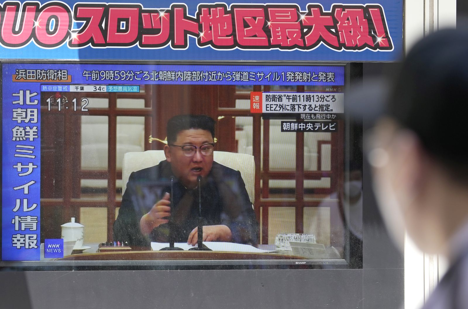epa10740729 A pedestrian watches a display showing news of North Korea firing a ballistic missile, accompanied by an image of North Korean leader Kim Jong-un, in Tokyo, Japan, 12 July 2023. The missile fired by North Korea fell into the sea outside the Japanese Exclusive Economic Zone (EEZ), Japan's Defense Ministry announced on 12 July 2023.  EPA/KIMIMASA MAYAMA