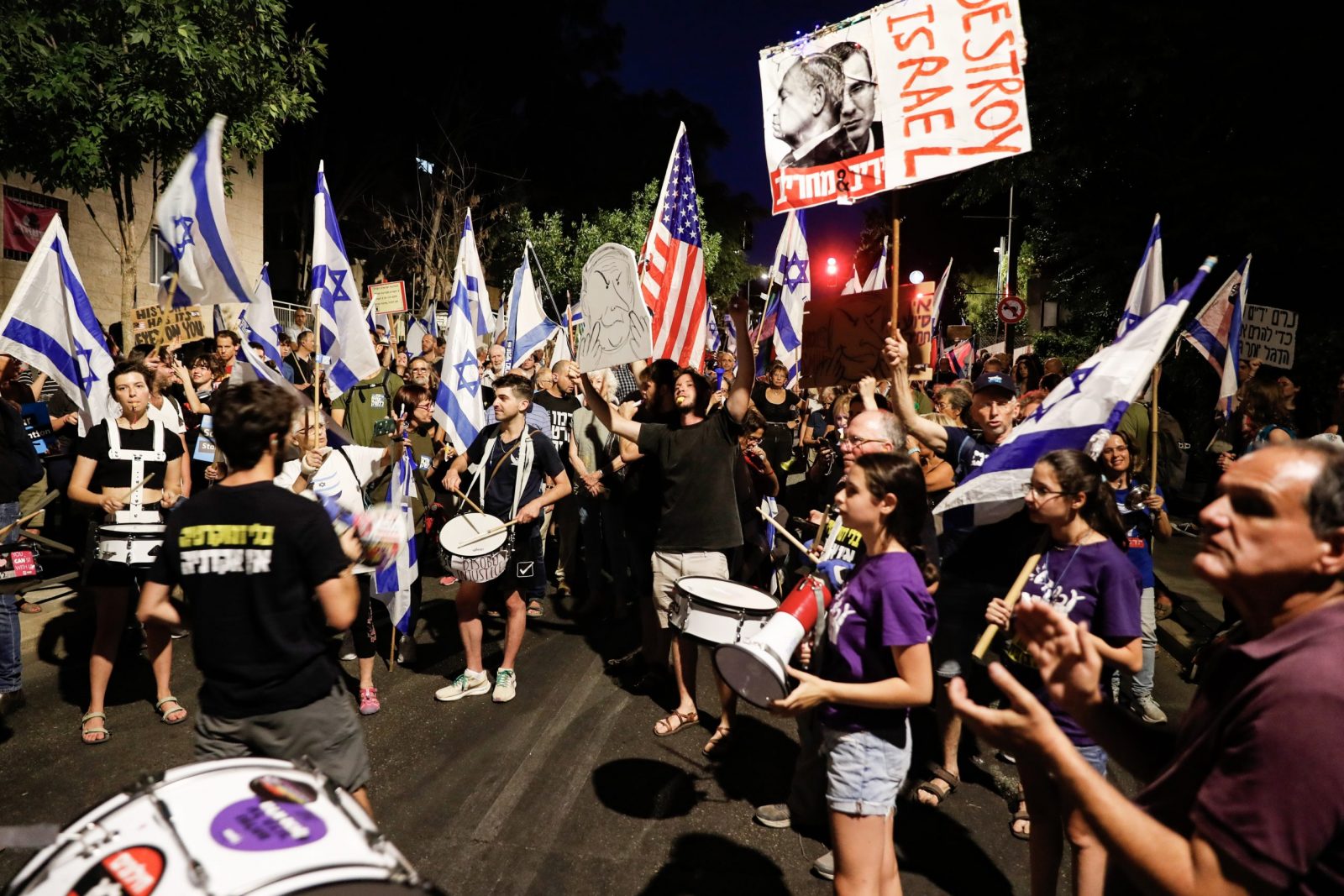 epa10744392 Anti-government protesters play the drums and wave flags as they gather near Israeli Prime Minister Benjamin Netanyahu's residence during a protest against the government's justice system reform plan, in Jerusalem, 13 July 2023.  EPA/ATEF SAFADI