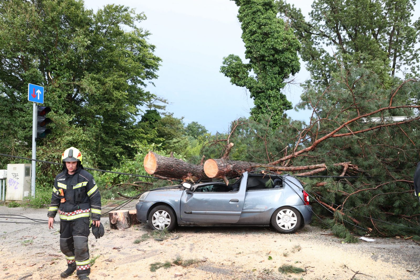 Zagreb, 19.07.2023 - Olujno nevrijeme u Zagrebu. Na slici vatrogasci kod automobila na kojeg je palo stablo i ozlijedilo jednu ensku osobu. 
foto HINA/ Damir SENÈAR/ ua