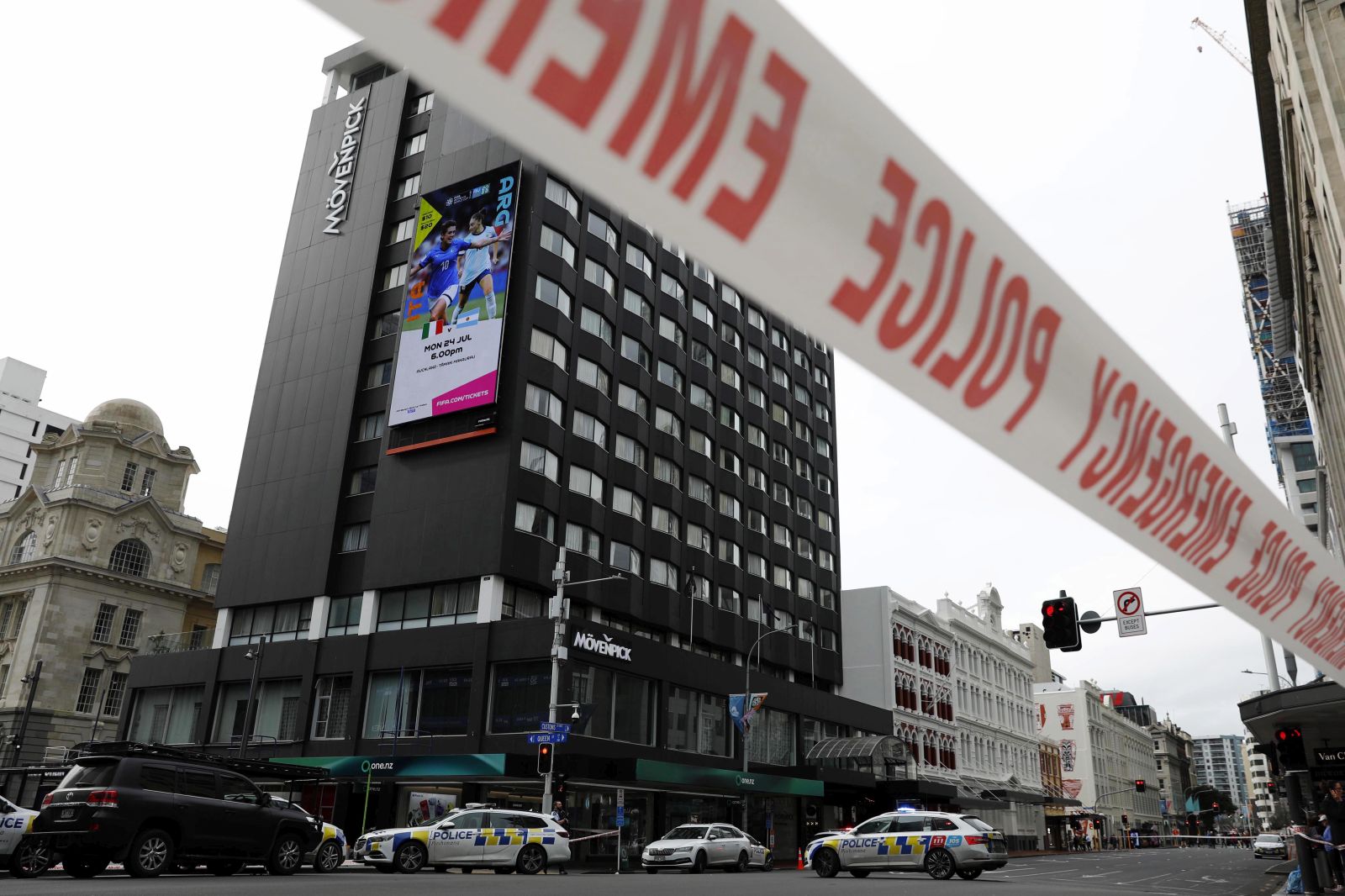 epaselect epa10756608 A digital display (top left) announcing a FIFA Women's World Cup fixture is seen as police block an area near the site of a shooting in Queen Street, Auckland, New Zealand, 20 July 2023. New Zealand Prime Minister Chris Hipkins confirmed in a press conference that a gunman killed two and injured six people, before being killed. The FIFA Women's World Cup is beginning on 20 July.  EPA/HOW HWEE YOUNG