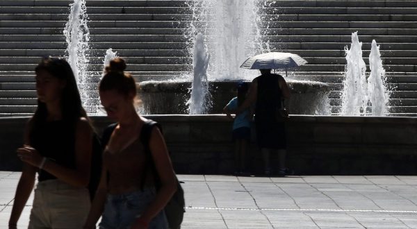 epa10761598 People walk past a fountain as they make their way through central Syntagma square amidst high temperatures, in Athens, Greece, 22 July 2023. Temperatures are expected to climb up to 44 on the Celsius scale in some parts of Greece on 22 July, while on 23 July they may even touch a sizzling 45 Celsius degrees in eastern parts of the country.  EPA/ORESTIS PANAGIOTOU
