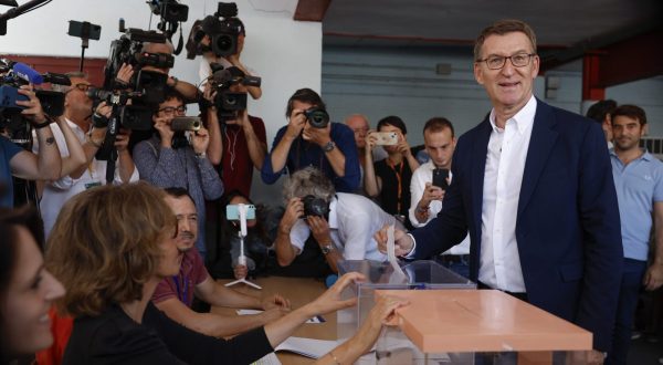 epa10763588 Spanish main opposition People's Party leader and candidate for Prime Minister Alberto Nunez Feijoo (R) casts his ballot for the general elections at a polling station in Madrid, Spain, 23 July 2023. Spanish voters head to polling stations on 23 July to vote for the lower and the upper house of the country's parliament.  EPA/CHEMA MOYA