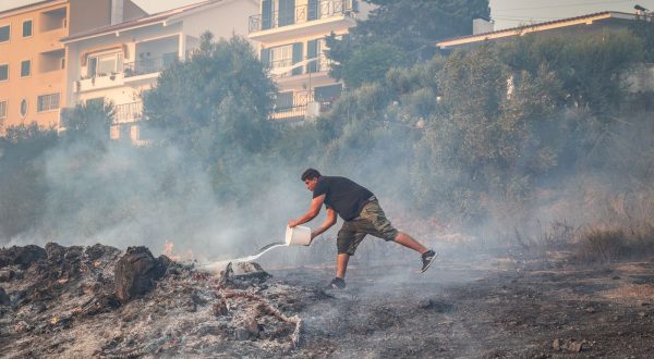 epa10768498 A man battles the flames in Alto do Alvide, Cascais, Portugal, 25 July 2023. 423 operatives, supported by 111 vehicles and 14 aerial means, are fighting a fire that broke out in Alcabideche, in the municipality of Cascais, near Lisbon.  EPA/MANUEL DE ALMEIDA