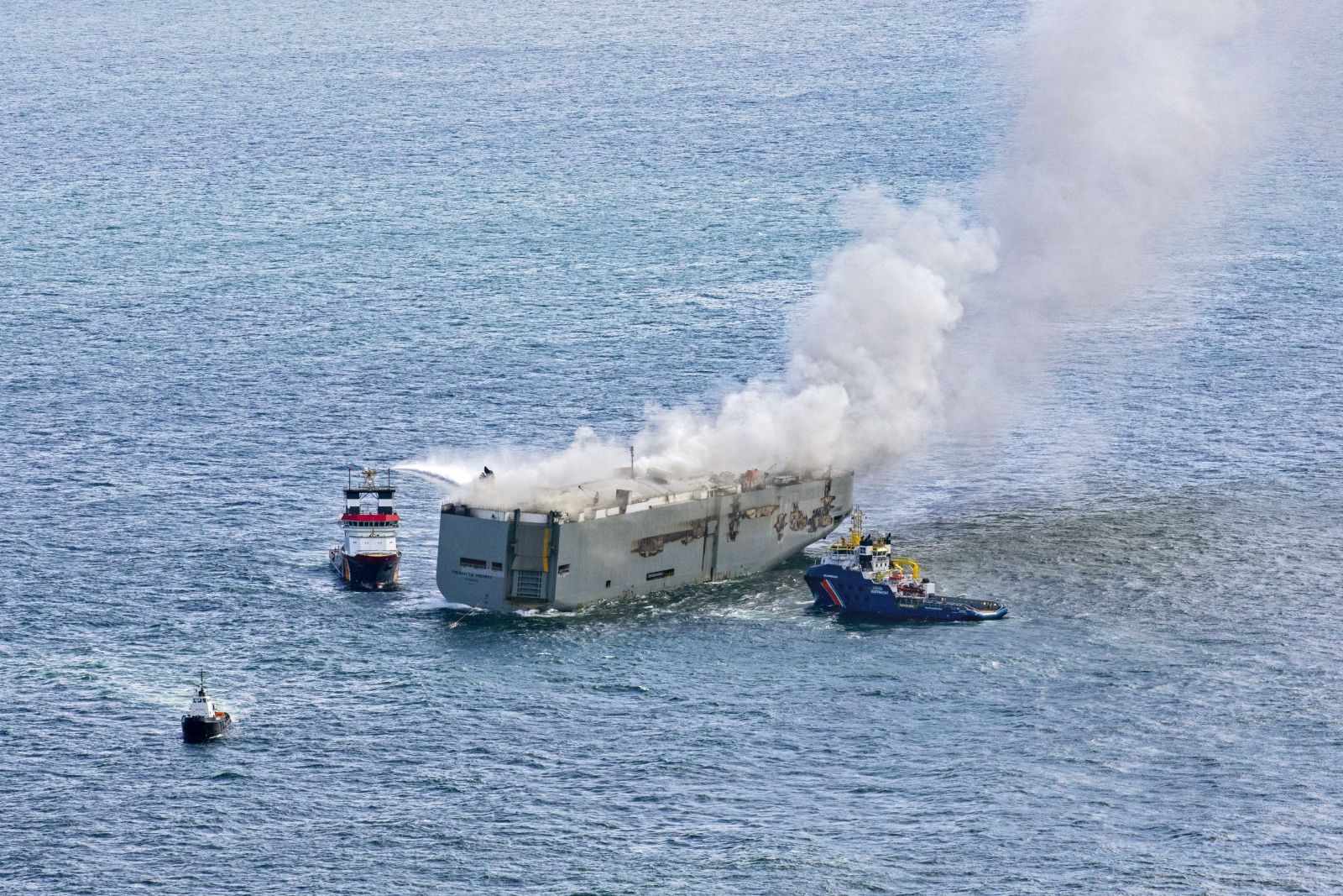 epa10769258 An aerial view shows fire extinguishing operation taking place as smoke rises from the Fremantle Highway cargo ship, in the North Sea, Ameland, the Netherlands,  16 July 202.3 A fire broke out overnight on 26 July on a freighter with 23 crew members onboard, in the North Sea, north of Ameland. According to the Dutch Coast Guard, one person died, and several got hurt.  EPA/Flying Focus BV