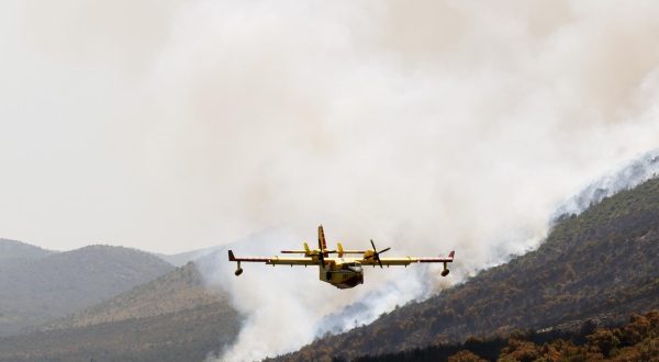 16.07.2023., Grebastica - Gaseci novi pozar u Grebastici piloti kanadera odsevljavali kupace na lokalnoj plazi svojim manevarskim sposobnostima. Photo: Hrvoje Jelavic/PIXSELL
