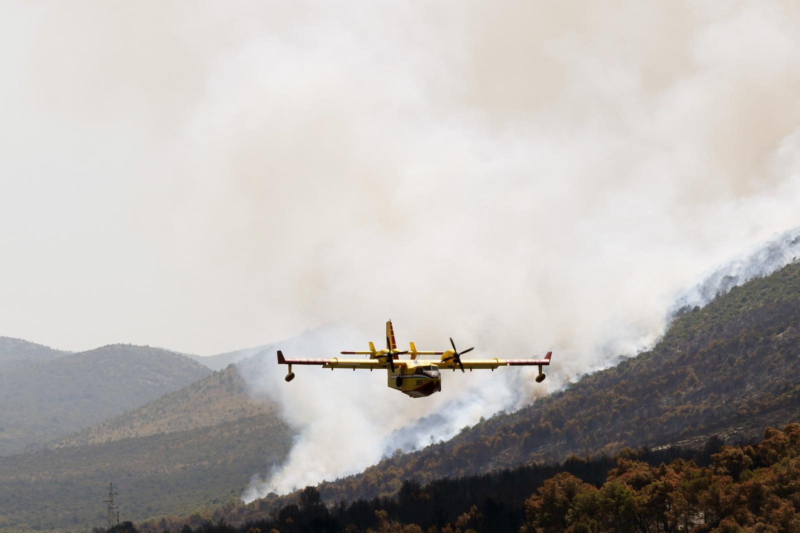 16.07.2023., Grebastica - Gaseci novi pozar u Grebastici piloti kanadera odsevljavali kupace na lokalnoj plazi svojim manevarskim sposobnostima. Photo: Hrvoje Jelavic/PIXSELL
