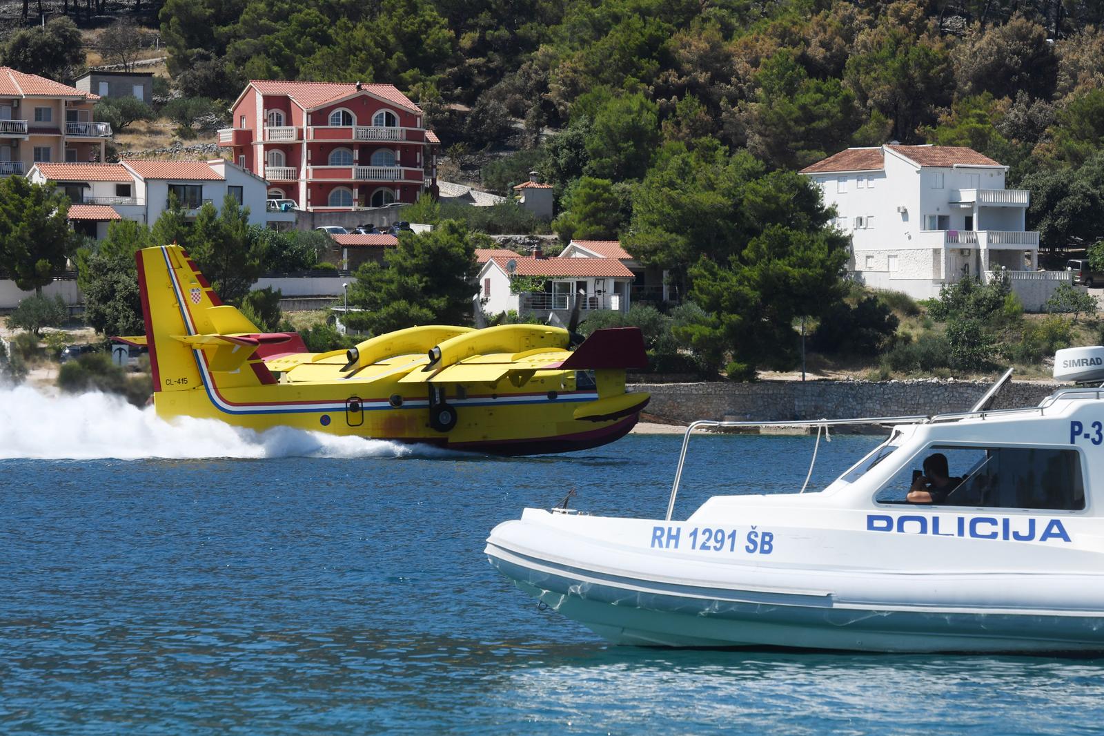 16.07.2023., Grebastica - Gaseci novi pozar u Grebastici piloti kanadera odsevljavali kupace na lokalnoj plazi svojim manevarskim sposobnostima. Photo: Hrvoje Jelavic/PIXSELL