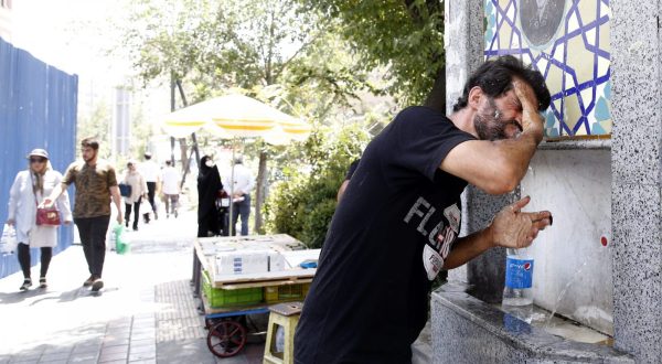 epa10727361 An Iranian man splashes water into his face at a public water well to cool off during a hot and sunny day in Tehran, Iran, 05 July 2023. Iran is facing a heat wave weather with temperatures above 35 degrees Celsius and forcasters'predictions of up to 40 degrees and more in the upcoming week.  EPA/ABEDIN ATEHRKENAREH