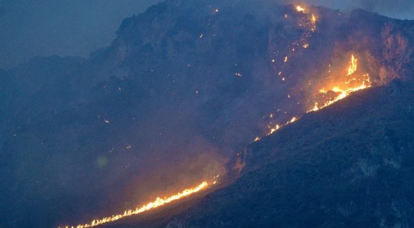 epa10767206 Flames rise as a wildfire burns on the hills surrounding the Monte Grifone area and the town of Ciaculli, near Palermo, Italy, 25 July 2023. The Palermo Airport was temporarily closed to air traffic in the morning of 25 July after wildfires in the hills around the Sicilian city reached the airport perimeter.  EPA/STR