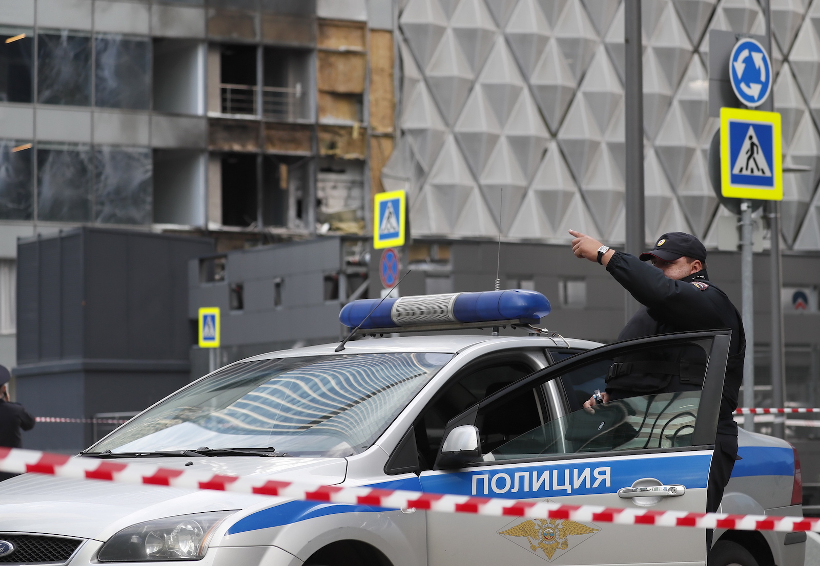 epa10776519 A police officer gestures near a cordon at the site of a damaged building following a reported drone attack in Moscow, Russia, 30 July 2023. The Russian Ministry of Defense on 30 July accused Ukraine of carrying out an attack with three unmanned aerial vehicles (UAV) against facilities in Moscow, adding that the attack was foiled and the three UAVs 'were suppressed by means of electronic warfare and crashed' leaving no casualties.  EPA/YURI KOCHETKOV