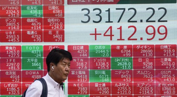 epa10778241 A pedestrian walks past a display showing closing information of the Nikkei Stock Average in Tokyo, Japan, 31 July 2023. Tokyo stocks rebounded after the Bank of Japan decided on 28 July 2023 to continue monetary easing policy. The Nikkei Sock Average gained 412.99 points to close at 33,172.22 after once rising more than 600 points.  EPA/KIMIMASA MAYAMA
