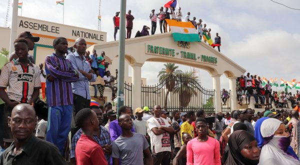 epaselect epa10783070 Protesters display the flag of Niger at the entrance to the National Assembly during a rally in Niamey, Niger, 03 August 2023. Protesters rallied against the sanctions imposed on their country by the Economic Community of West African States, (ECOWAS), to demand the departure of the French military from the country and expressed their support for the junta. On 26 July General Abdourahamane Tchiani declared himself the new leader of Niger, after a coup against democratically elected President Mohamed Bazoum.  EPA/ISSIFOU DJIBO