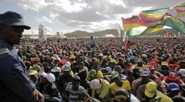 epa10786808 A police officer (L) watches supporters who attended an election campaign rally  addressed by President and party leader Emmerson Mmangagwa in Uzumba, Maramba, Zimbabwe, 05 August 2023. Zimbabweans go to the polls on 23 August 2023.  EPA/AARON UFUMELI