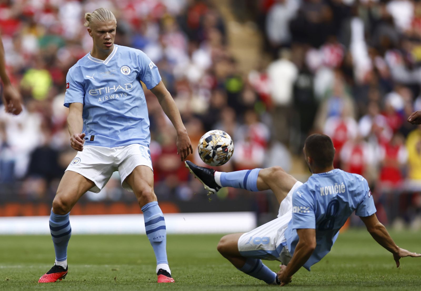 epa10787683 Mateo Kovacic (R) and Erling Haaland (L) of Manchester City in action during the FA Community Shield soccer match between Arsenal London and Manchester City in London, Britain, 06 August 2023.  EPA/TOLGA AKMEN