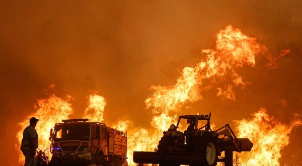 epa10789282 A man watches the fire in the municipality of Odemira, 07 August 2023.  The fire, which broke out in the Baiona area, in the parish of São Teotónio, 05 August, has already forced the evacuation of four locations in the municipality of Odemira (Vale dos Alhos, Vale de Água, Choça dos Vales and Relva Grande) and a rural tourism unit.  EPA/LUIS FORRA