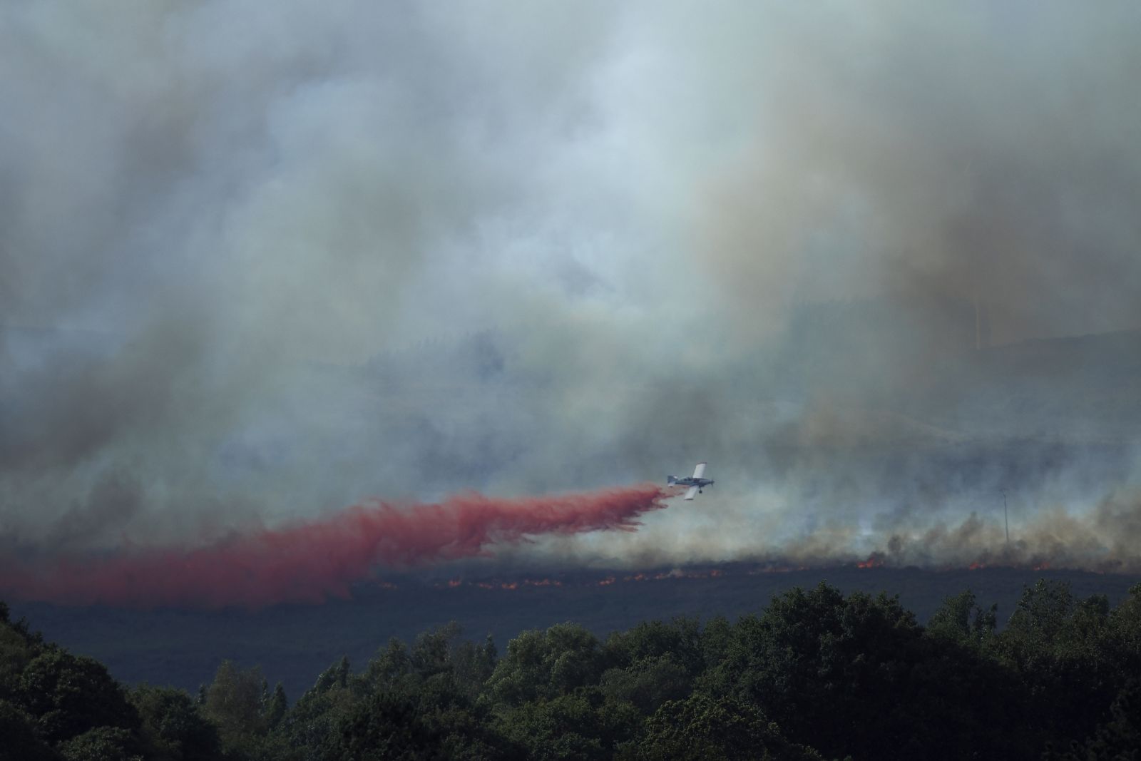 epa10805986 An aircraft takes part in extinction works of a forest fire originated in Palas de Rei, Lugo, northern Spain, 18 August 2023. The fire has already burnt around 20 hectares and over 40 assets have been deployed in the area.  EPA/Eliseo Trigo