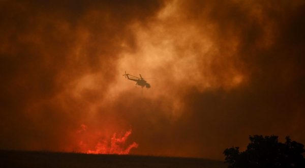epa10812681 A firefighting helicopter drops water to extinguish a wildfire in Avantas village, near the city of Alexandroupolis, Thrace, northern Greece, 21 August 2023. The wildfire that broke out early on 19 August in a forest in the Melia area of Alexandroupolis has spread rapidly due to the strong winds blowing in the area and is raging uncontrolled. The major wildfire in Alexandroupolis continues with unabated intensity for the third consecutive day. According to the Fire Department, the fire is difficult to be contained due to the strong winds in the area.  EPA/DIMITRIS ALEXOUDIS