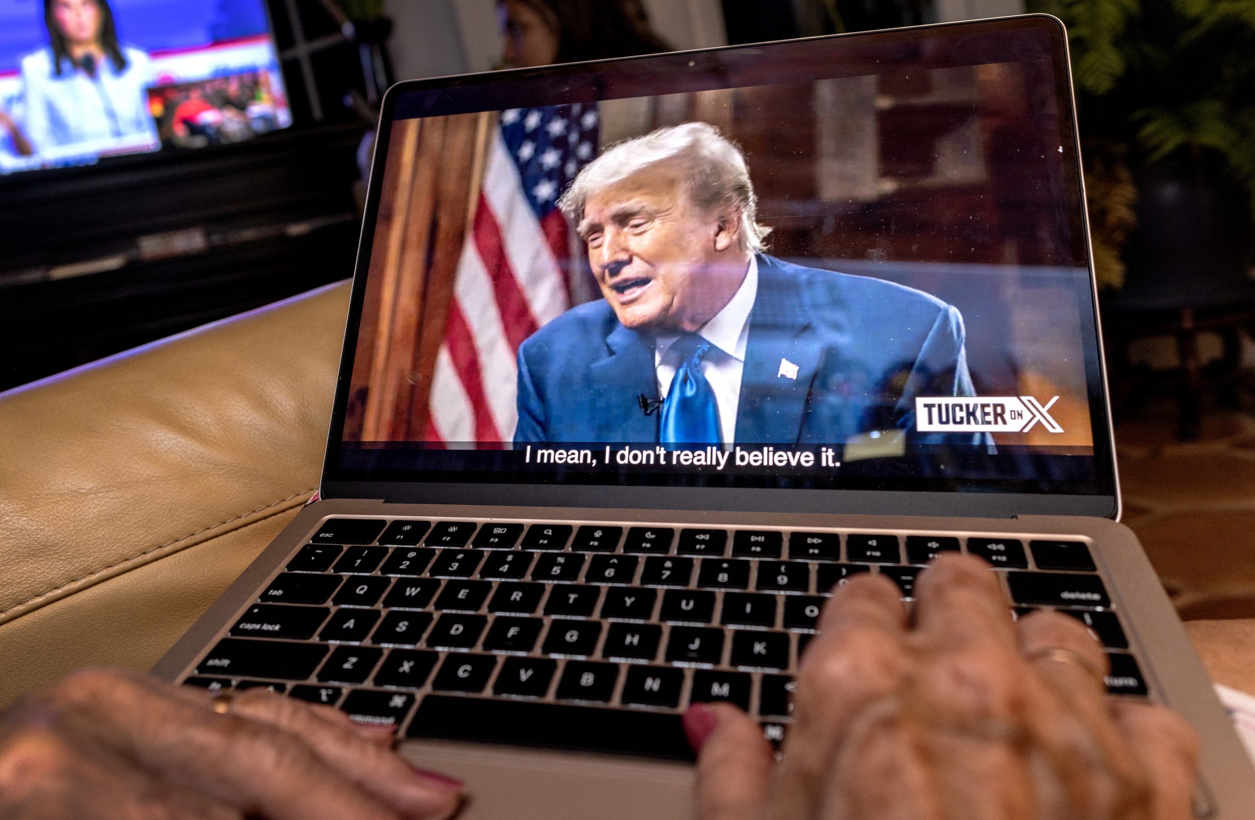 epa10816802 A viewer streams former President and Republican presidential candidate Donald Trump's interview by Tucker Carlson on the platform 'X' on their computer in Miami, Florida, USA, 23 August 2024. Trump chose not to attend the debate and instead do the interview with Carlson. The pre-recorded interview is being aired at the same time as the Republican presidential debate.  EPA/CRISTOBAL HERRERA-ULASHKEVICH