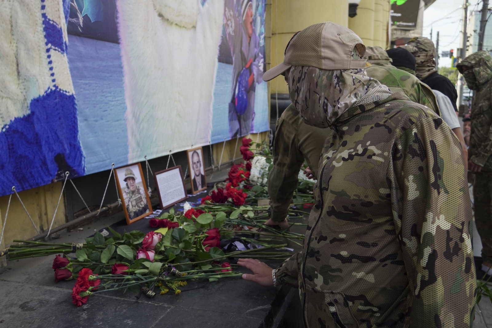 epa10817917 Men dressed in a military uniform brings flowers to an informal memorial with pictures of PMC Wagner chief  Yevgeny Prigozhin and PMC Wagner commander Dmitry Utkin in downtown of Rostov-on Don, Russia, 24 August 2023. An investigation was launched into the crash of an aircraft in the Tver region in Russia on 23 August 2023, the Russian Federal Air Transport Agency said in a statement. Among the passengers was Wagner chief Yevgeny Prigozhin, the agency reported.  EPA/STRINGER
