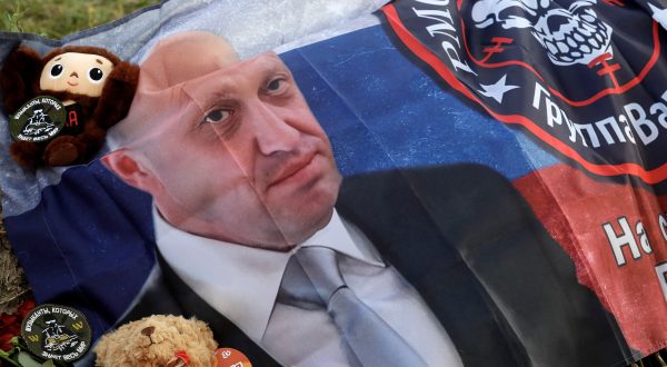 epa10820022 A flag with the image of Yevgeny Prigozhin and the emblem of the Wagner Group (PMC Wagner) is seen at an informal memorial held next to the former 'PMC Wagner Centre' in St. Petersburg, Russia, 25 August 2023. An investigation was launched into the crash of an aircraft in the Tver region in Russia on 23 August 2023, the Russian Federal Air Transport Agency said in a statement. Among the passengers was Wagner chief Yevgeny Prigozhin, the agency reported.  EPA/ANATOLY MALTSEV