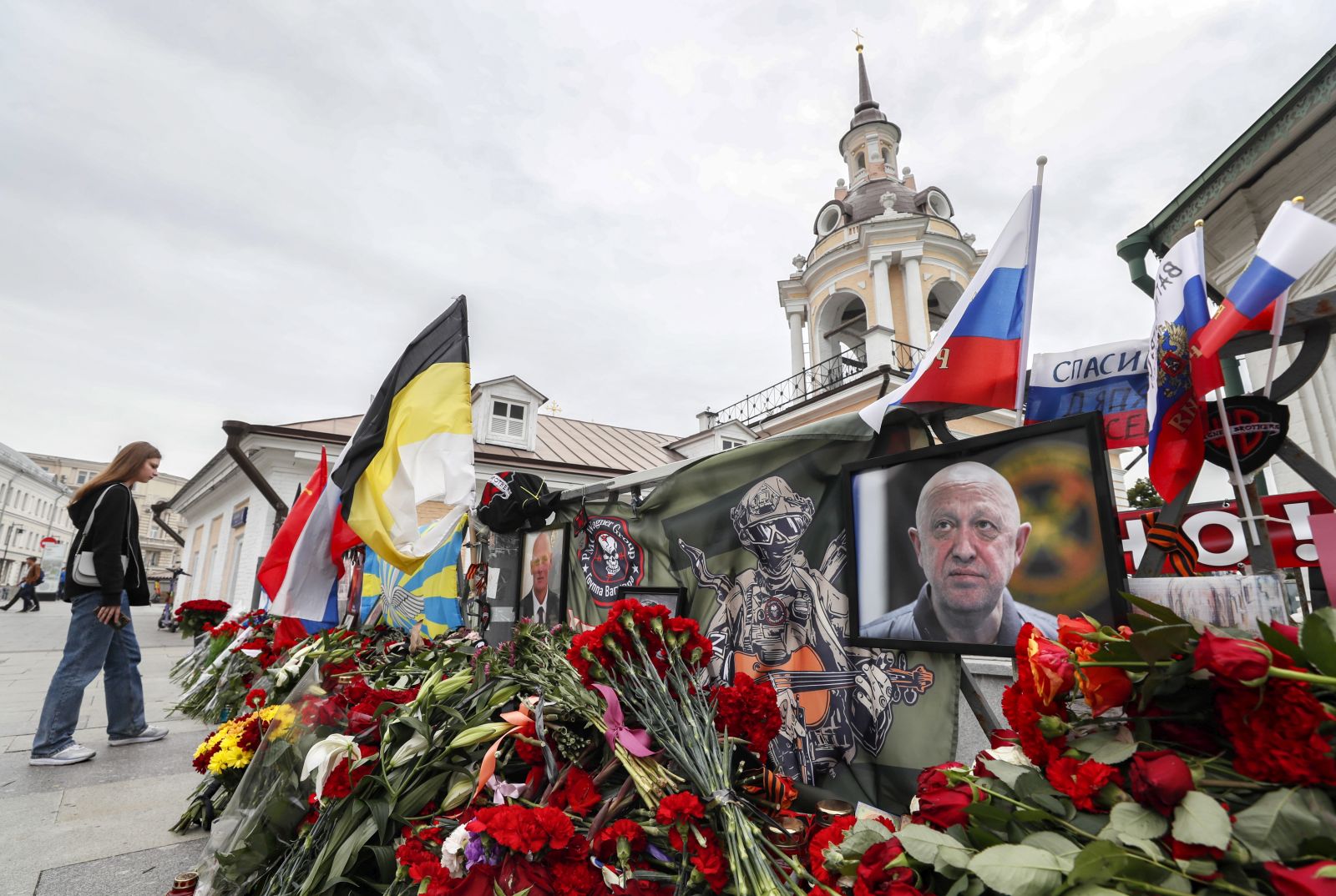 epa10821329 A woman bring flowers to an informal memorial to PMC Wagner chief Yevgeny Prigozhin in Moscow, Russia, 26 August 2023. An investigation was launched into the crash of an aircraft in the Tver region in Russia on 23 August 2023, the Russian Federal Air Transport Agency said in a statement. Among the passengers was Wagner chief Yevgeny Prigozhin, the agency reported.  EPA/YURI KOCHETKOV