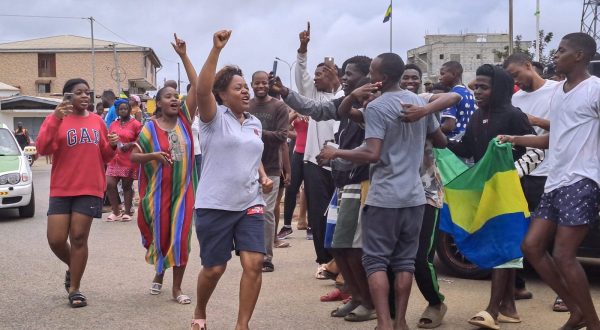 epa10828207 People display the Gabon national flag as they gather to celebrate in the streets of Akanda, Gabon, 30 August 2023. Members of the Gabonese army on 30 August announced on national television that they were canceling the election results and putting an end to Gabonese President Ali Bongo's regime, who had been declared the winner.  EPA/STRINGER