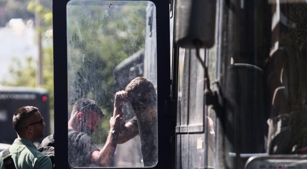 11.08.2023., Atena, Grcka - Prva skupina navijaca iz pritvora je prebacena na sud gdje u 12 sati pocinju saslusanja koja ce trajati do nedjelje. Uhicene, njih 105, ce dovoditi i ispitivati u grupama po 30 osoba. Prvi optuzenici za krvave incidente ispred stadiona AEK-a i ubojstvo 29-godisnjaka danas ce biti ispitani, a glavnu istragu vode tri istrazitelja, jedan redovni i dva pomocnika.  Photo: KOSTAS TZOUMAS/EUROKINISSI/PIXSELL