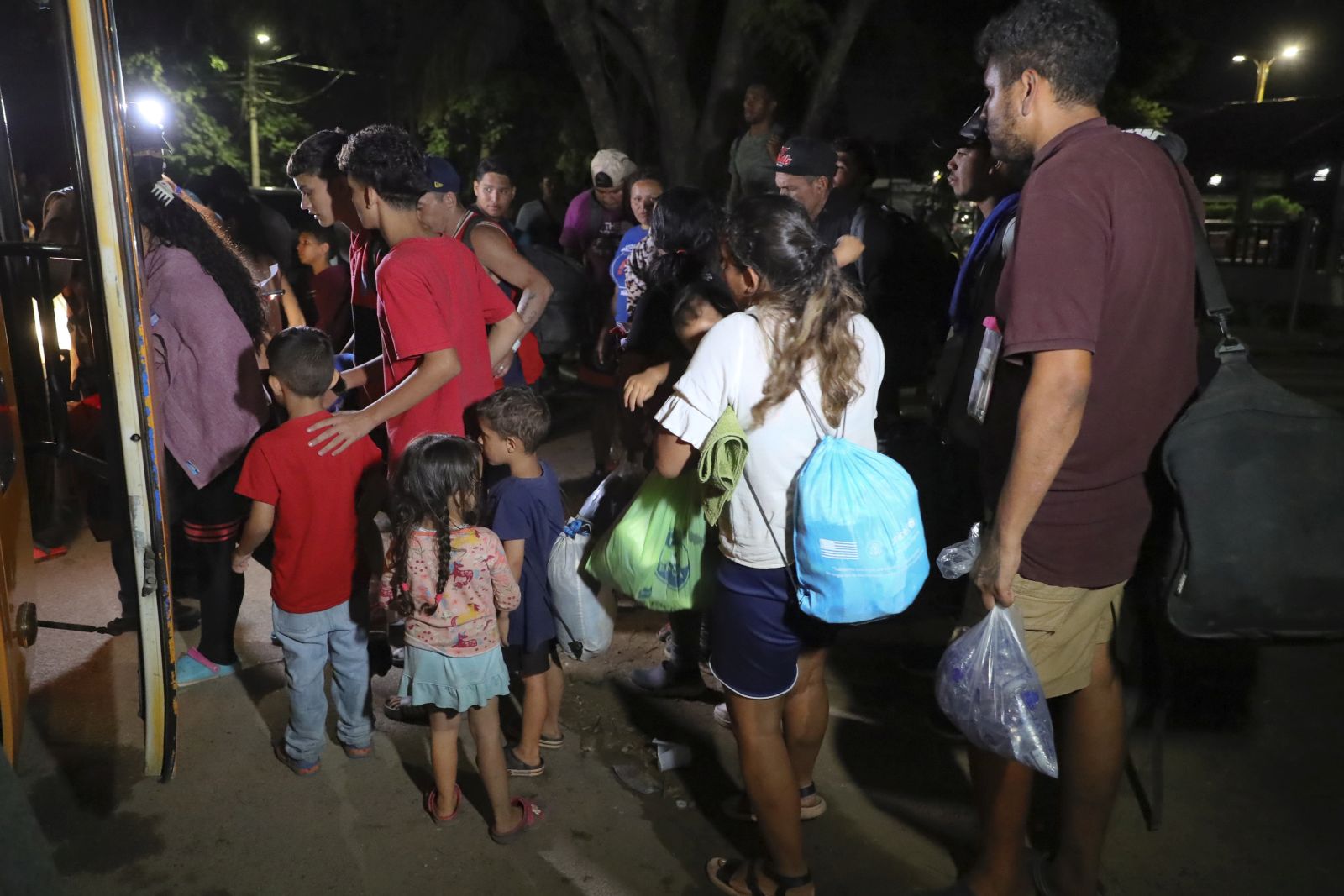 epa10820549 Migrant families board a bus in the park Monument to the Mother in the city of Danli, Honduras, early 25 August 2023. Hundreds of foreign children hide the pain of migration, playing on public roads or shelters, while their parents, some crying, cry out in Honduras for more solidarity to continue their trip to the US, in an odyssey that some families started two months ago. The thousands of migrants who are entering through eastern Honduras do not intend to stay in the country, but to leave as quickly as possible to continue on their way to the United States, which is difficult for most of them due to lack of money, according to their stories.  EPA/Gustavo Amador