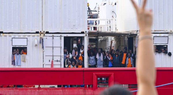 epaselect epa10824962 A person flashes a victory sign towards migrants aboard the 'Ocean Viking', the SOS Mediterranee ship that rescued 439 migrants between Lampedusa and Tunisia, as they arrive in the port of Naples, Italy, 28 August 2023.  EPA/CIRO FUSCO