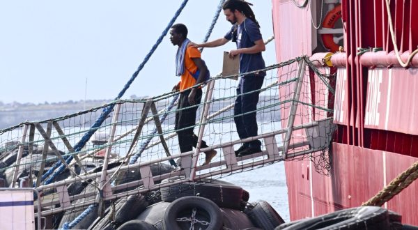 epa10824956 A migrant disembarks from the 'Ocean Viking', the SOS Mediterranee ship that rescued 439 migrants between Lampedusa and Tunisia, after arriving in the port of Naples, Italy, 28 August 2023.  EPA/CIRO FUSCO