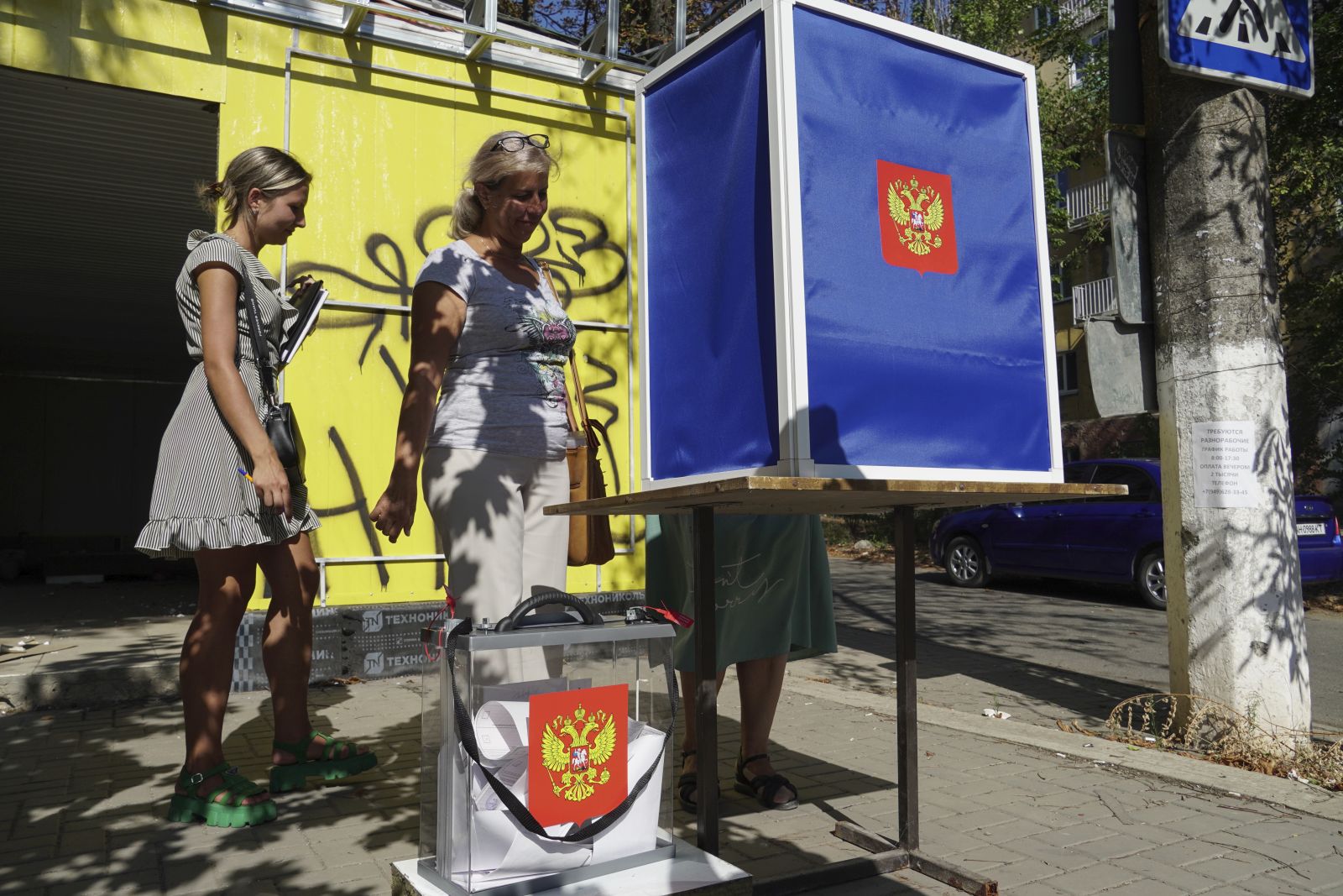 epa10831652 Women cast their ballots at a mobile polling station with the coat of arms of Russia during early voting for the local elections in Mariupol, Russian-controlled Ukraine, 31 August 2023. Elections of various levels will be held in Russia on 10 September 2023, including by-elections of deputies to the State Duma, elections of heads of 26 constituent entities of the federation, and elections of deputies of legislative bodies of state power in 16 constituent entities of the Russian Federation. The Central Election Commission of Russia has scheduled elections in the self-proclaimed Donetsk People’s Republic, Luhansk, Zaporizhzhia and Kherson regions on a Single Voting Day on 10 September.  EPA/STRINGER