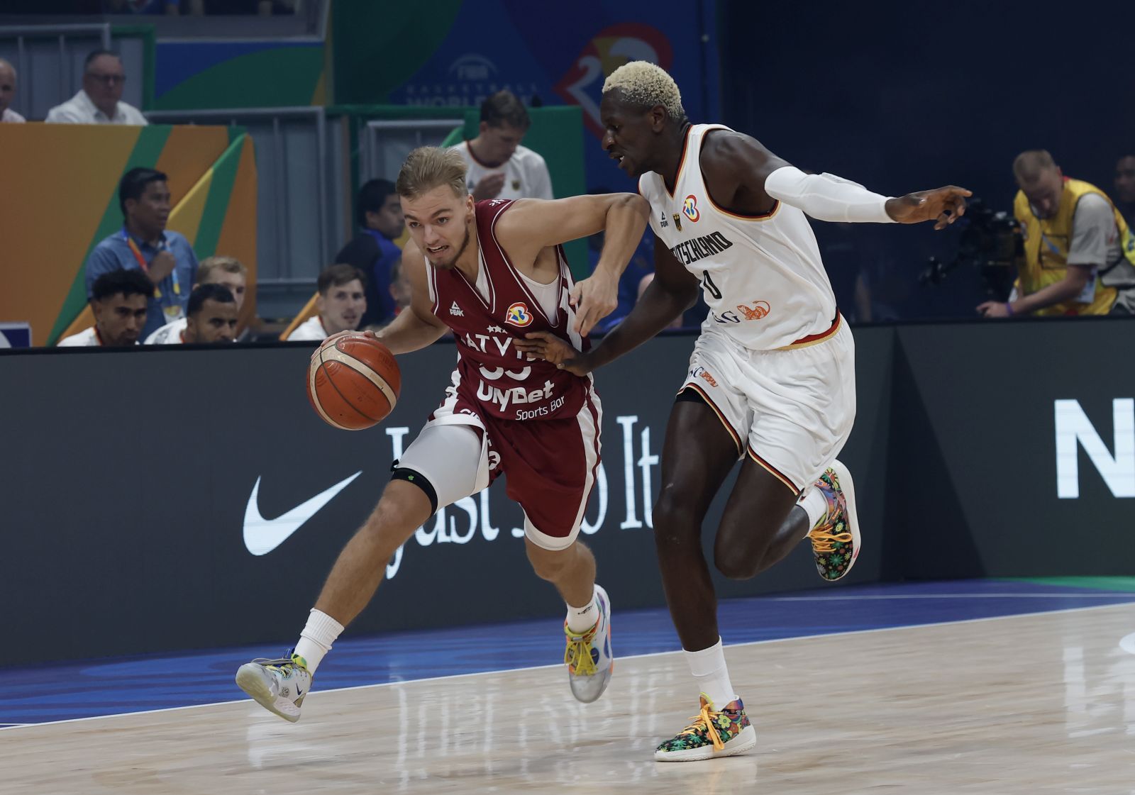 epa10843395 Arturs Zagars of Latvia (L) in action against Isaac Bonga of Germany (R) during the FIBA Basketball World Cup 2023 quarter final match between Germany and Latvia in Manila, Philippines, 06 September 2023.  EPA/ROLEX DELA PENA