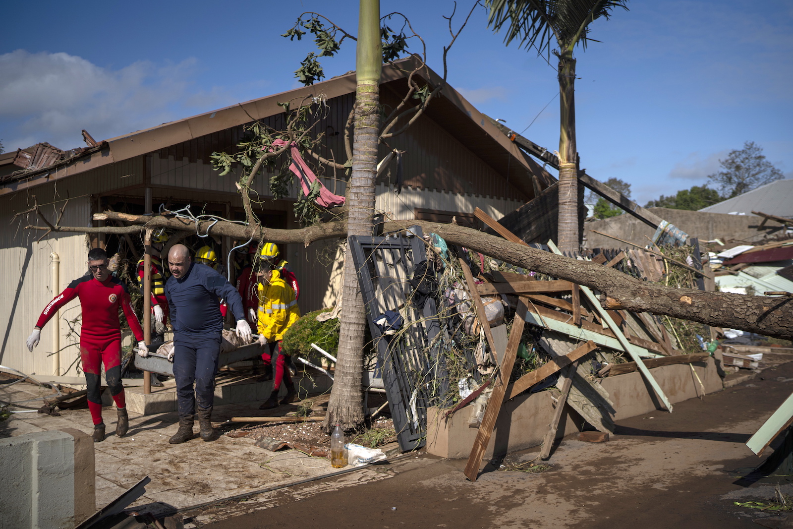 epa10844691 Firefighters carry the dead body of a victim after the passage of an extratropical cyclone, in Roca Sales, municipality of Rio Grande do Sul, Brazil, 06 September 2023. According to the Civil Defense on 06 September, the number of deaths due to the passage of an extratropical cyclone in southern Brazil rose to 28, with six new victims reported by authorities in Roca Sales.  EPA/Daniel Marenco