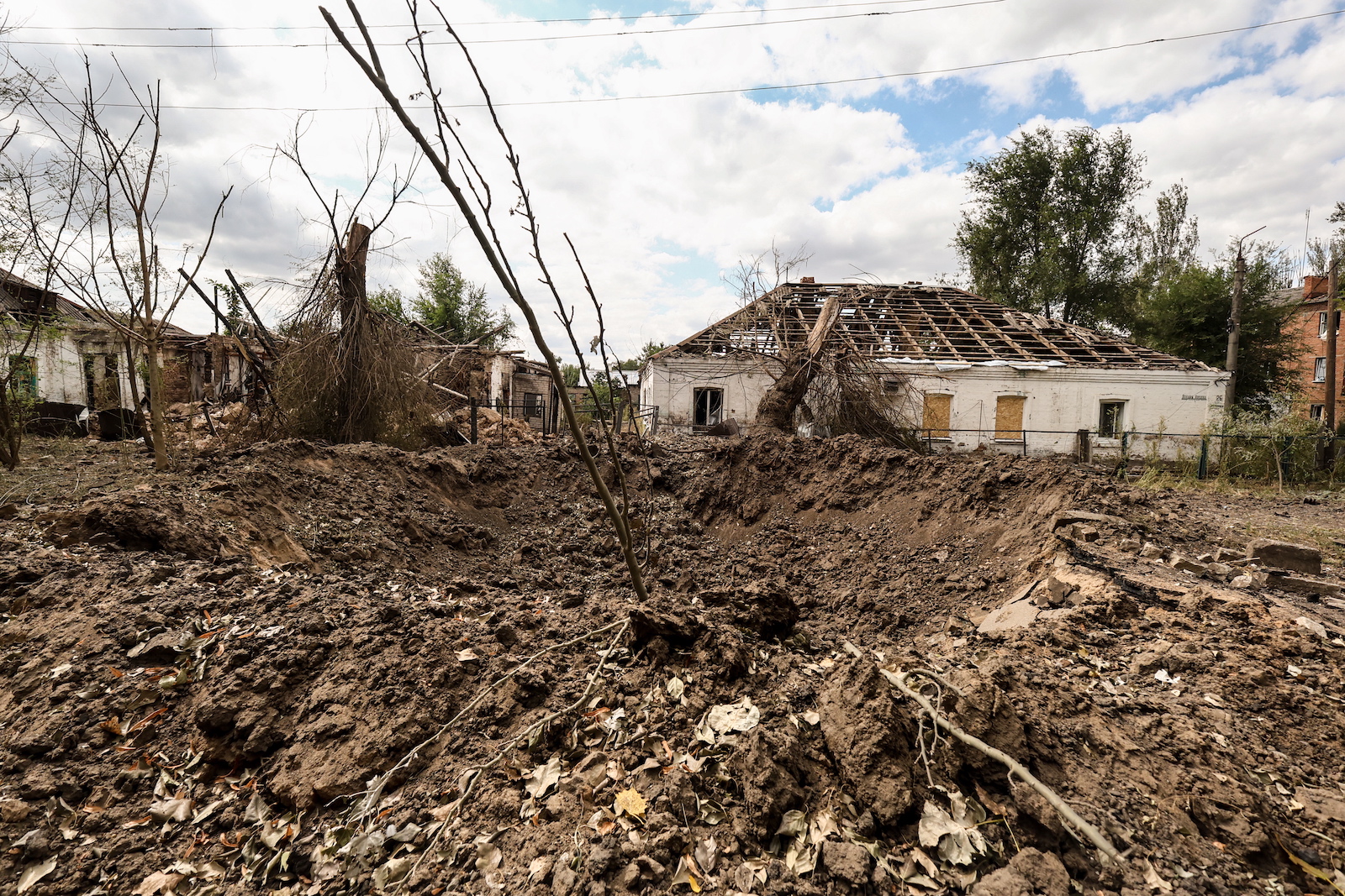 epa10846748 A shell crater in the frontline town of Orikhiv, Zaporizhzhia Oblast, Ukraine, 07 September 2023, amid the Russian invasion. The town, located less than 10 kilometers from the nearest Russian army position, witnesses daily attacks from Russian forces. Its school was operating as a center for distribution of humanitarian aid until the premises were hit by two consecutive air strikes. Airstrike survivor Lubov Jarova says that her dog saved her life. Following the first strike, she ran after it outside the school when the second strike happened, destroying the building and killing seven people. Today Lubov lives in Zaporizhzhia, around 65 kilometers north-west, and she occasionally brings humanitarian aid to her hometown. Before the war, Orikhiv had a population of over 14,000. The town is currently home to around 700 people.  EPA/KATERYNA KLOCHKO  ATTENTION: This Image is part of a PHOTO SET
