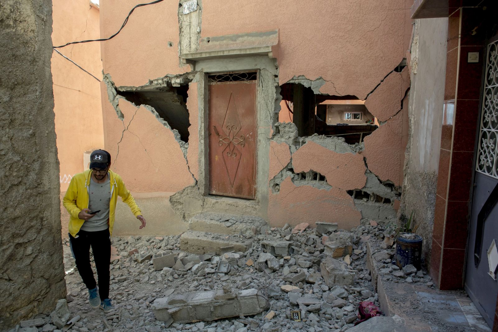 epa10850165 A person walks over debris next to a damaged building following an earthquake in Marrakesh, Morocco, 09 September 2023. A powerful earthquake that hit central Morocco late 08 September, killed at least 820 people and injured 672 others, according to a provisional report from the country's Interior Ministry. The earthquake, measuring magnitude 6.8 according to the USGS, damaged buildings from villages and towns in the Atlas Mountains to Marrakesh.  EPA/JALAL MORCHIDI