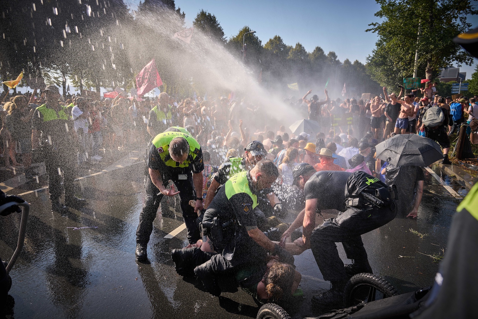 epa10850807 Police use water cannons to disperse climate activists from the 'Extinction Rebellion' group blocking the Utrechtsebaan on the A12 route in The Hague, Netherlands, 09 September 2023. The demonstrators demand that the government immediately stop granting fossil subsidies, including all financial arrangements that favor the use of fossil fuels.  EPA/PHIL NIJHUIS