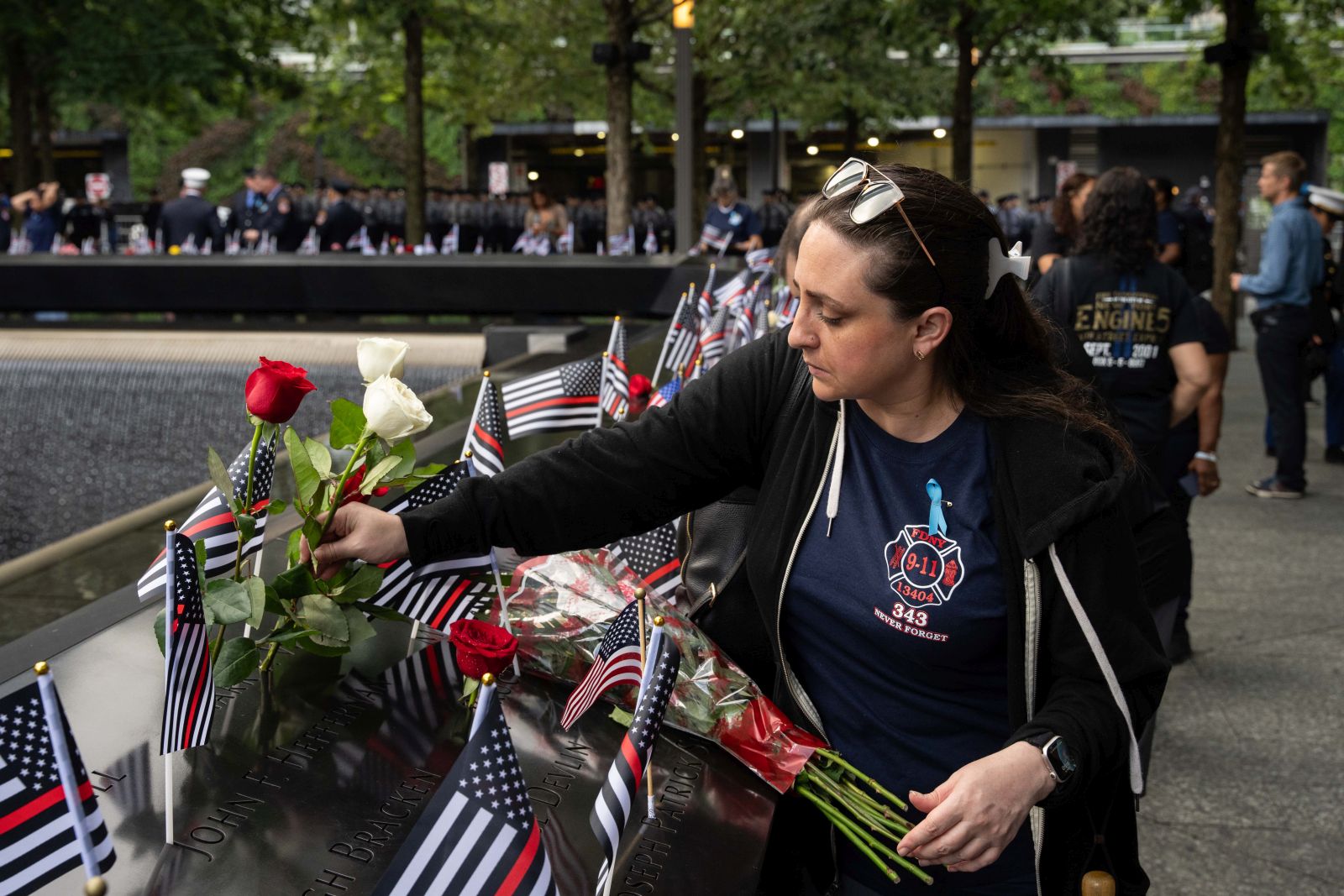 epa10854767 Clare Baron lays a rose for her cousin Mark Whitford at the National September 11 Memorial during an annual ceremony to commemorate the 22nd anniversary of the September 11, 2001 terrorist attacks in New York, New York, USA, 11 September 2023.  The USA is commemorating the 22nd anniversary of the terrorist attack of 11 September 2001, when terrorists flew hijacked planes into the World Trade Center, the Pentagon, and crashed a plane in Shanksville, Pennsylvania.  EPA/ADAM GRAY